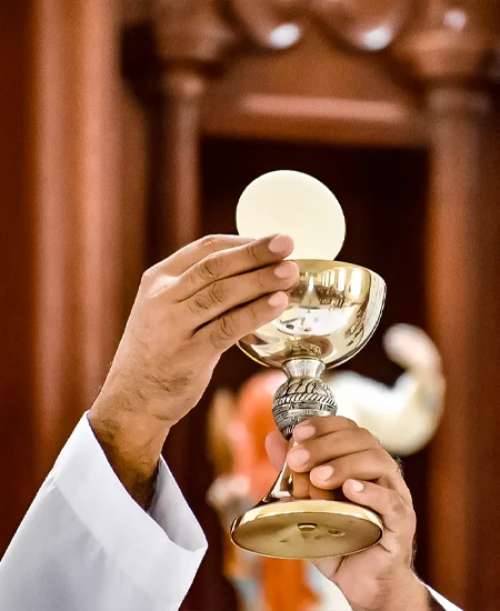 Padre apresentando o Corpo e Sangue de Cristo na Santa Missa.